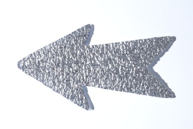 Photo of Silver tinfoil arrow on white background, top view