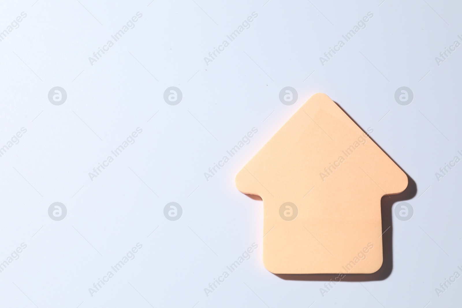 Photo of One orange paper arrow on white background, top view. Space for text