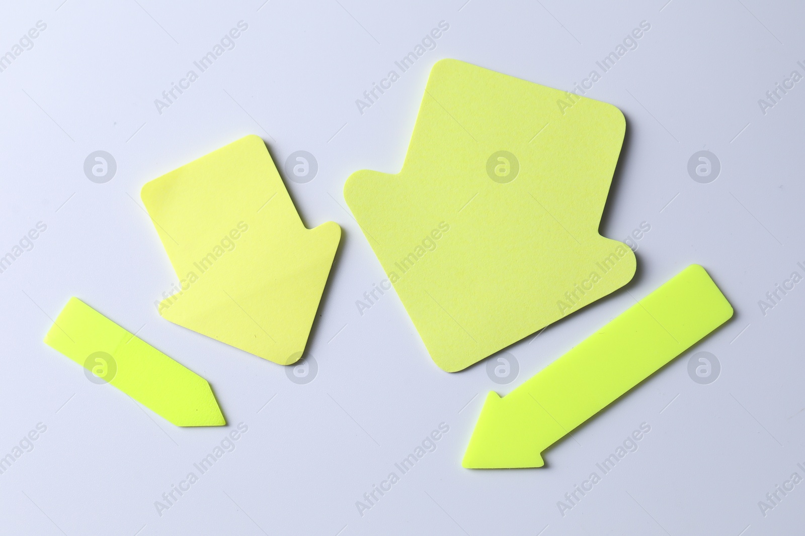 Photo of Yellow paper arrows on white background, flat lay