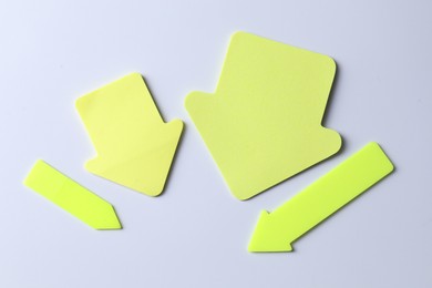 Photo of Yellow paper arrows on white background, flat lay