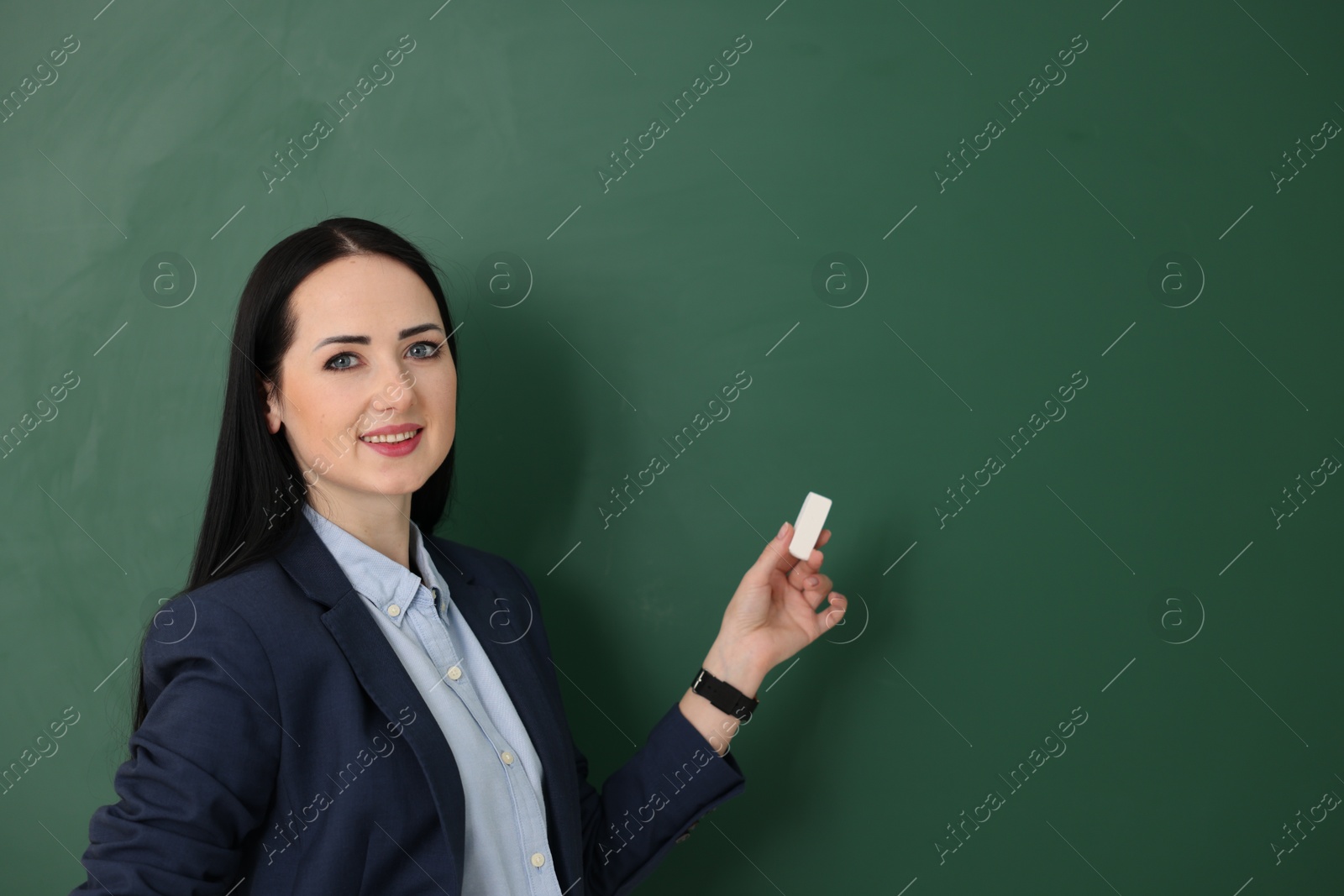 Photo of English teacher near chalkboard in classroom. Space for text