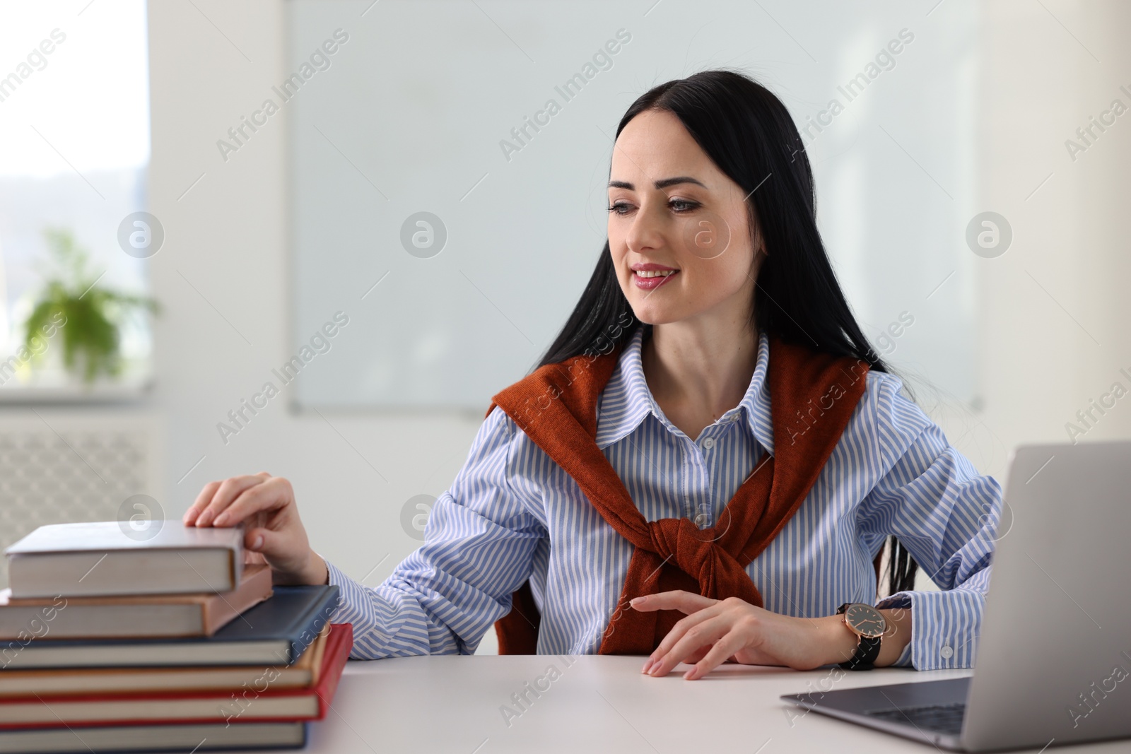 Photo of English teacher working at desk in classroom