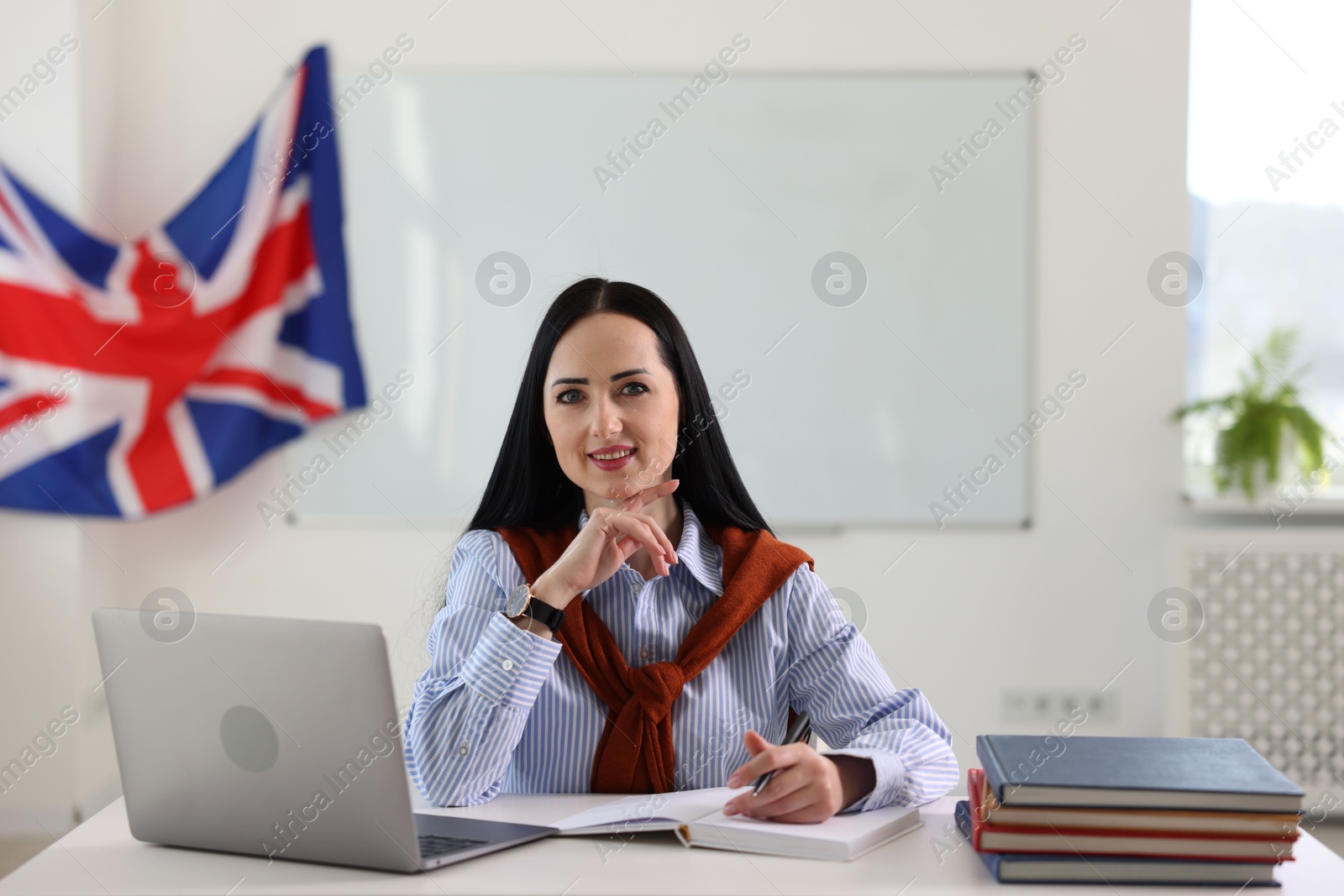 Photo of English teacher working at desk in classroom