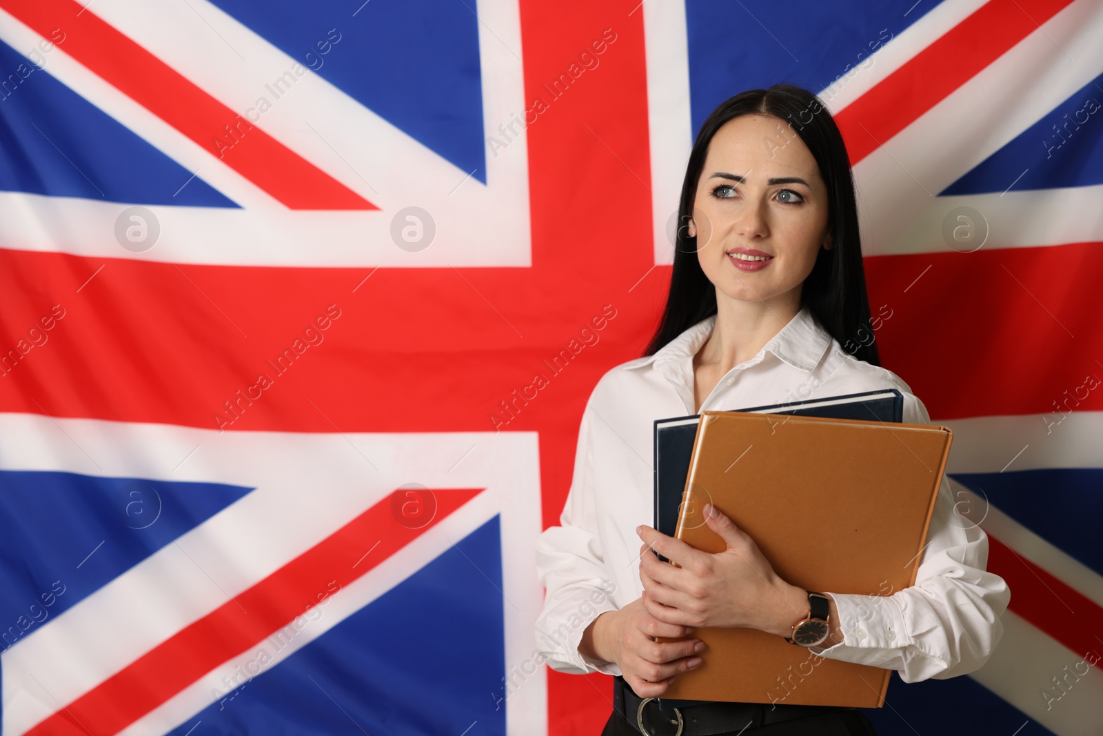 Photo of English teacher with books against UK flag. Space for text