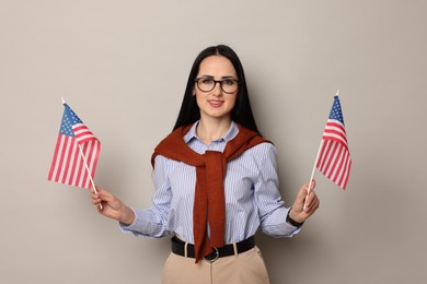 Photo of English teacher with American flags on light grey background