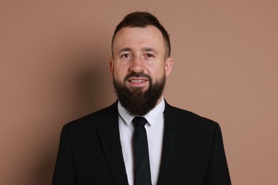 Photo of Handsome bearded man in suit on brown background