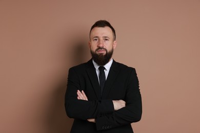 Photo of Handsome bearded man in suit on brown background