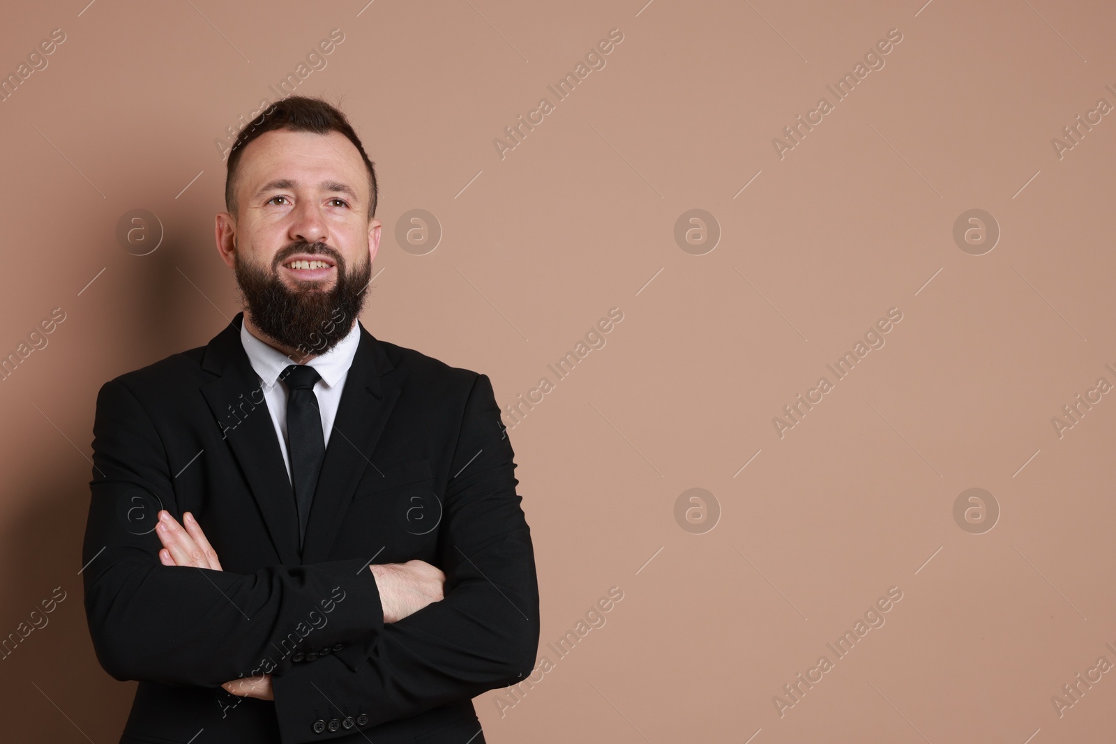 Photo of Handsome bearded man in suit on brown background. Space for text