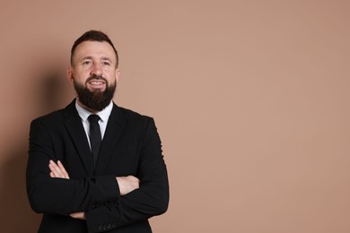 Photo of Handsome bearded man in suit on brown background. Space for text