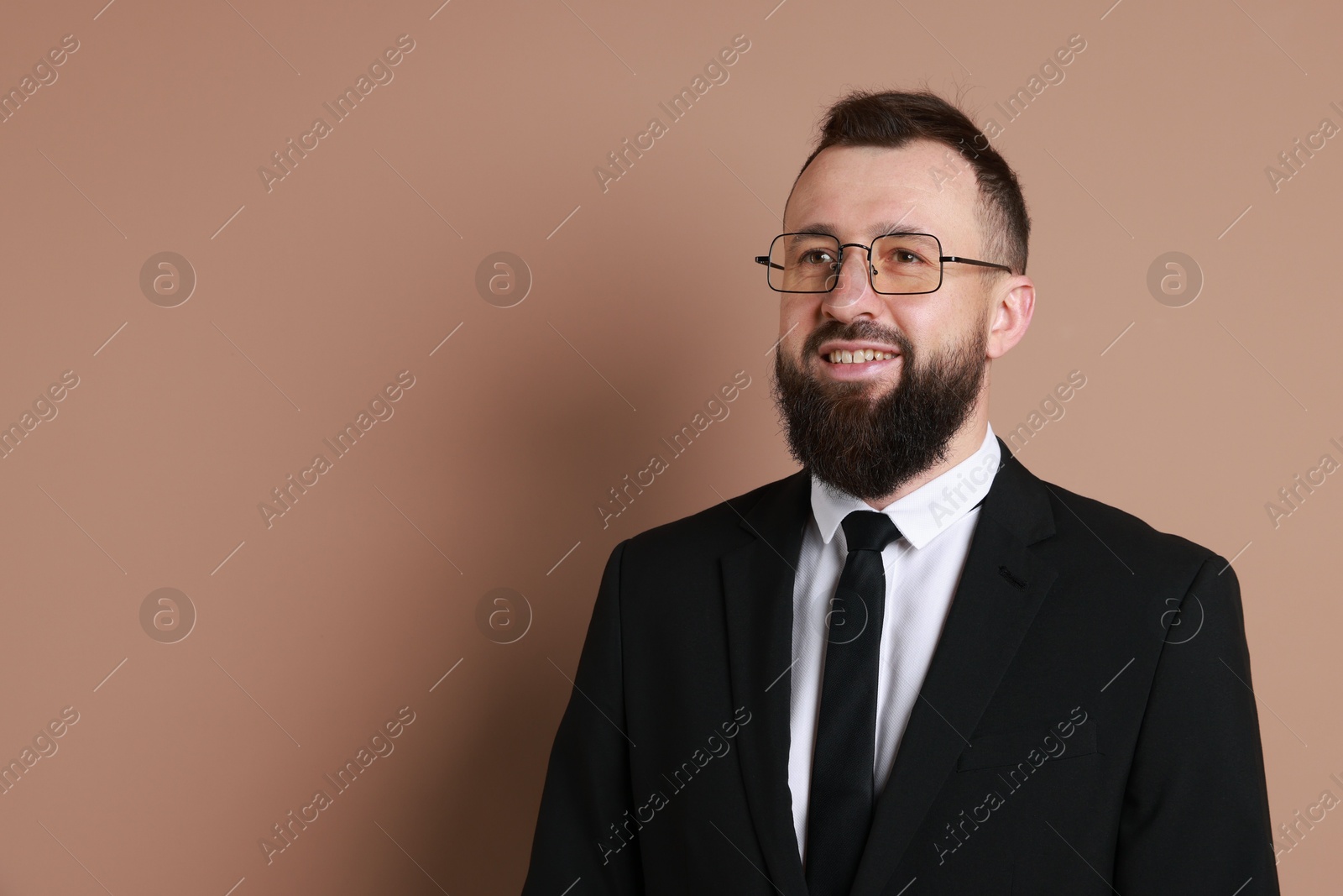 Photo of Handsome bearded man in suit on brown background. Space for text