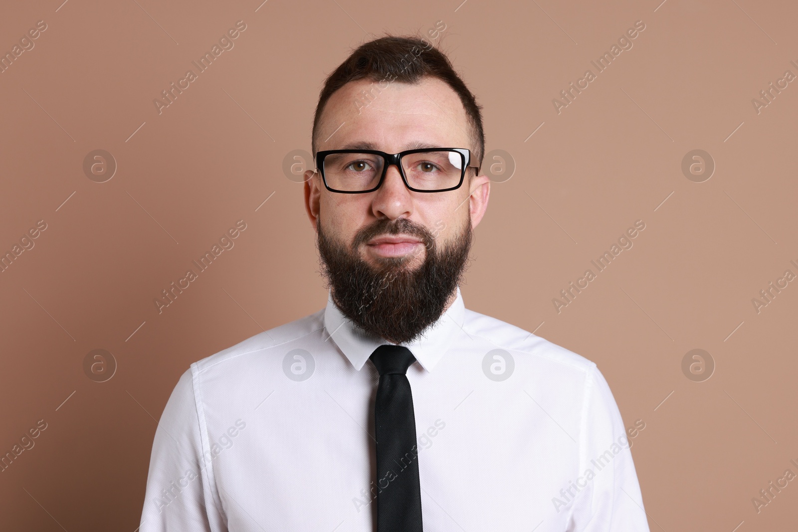 Photo of Handsome bearded man in formal outfit on brown background