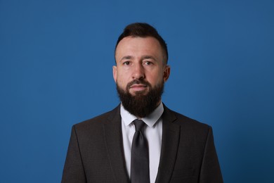 Photo of Handsome bearded man in suit on blue background