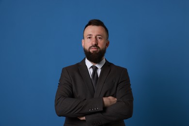 Photo of Handsome bearded man in suit on blue background