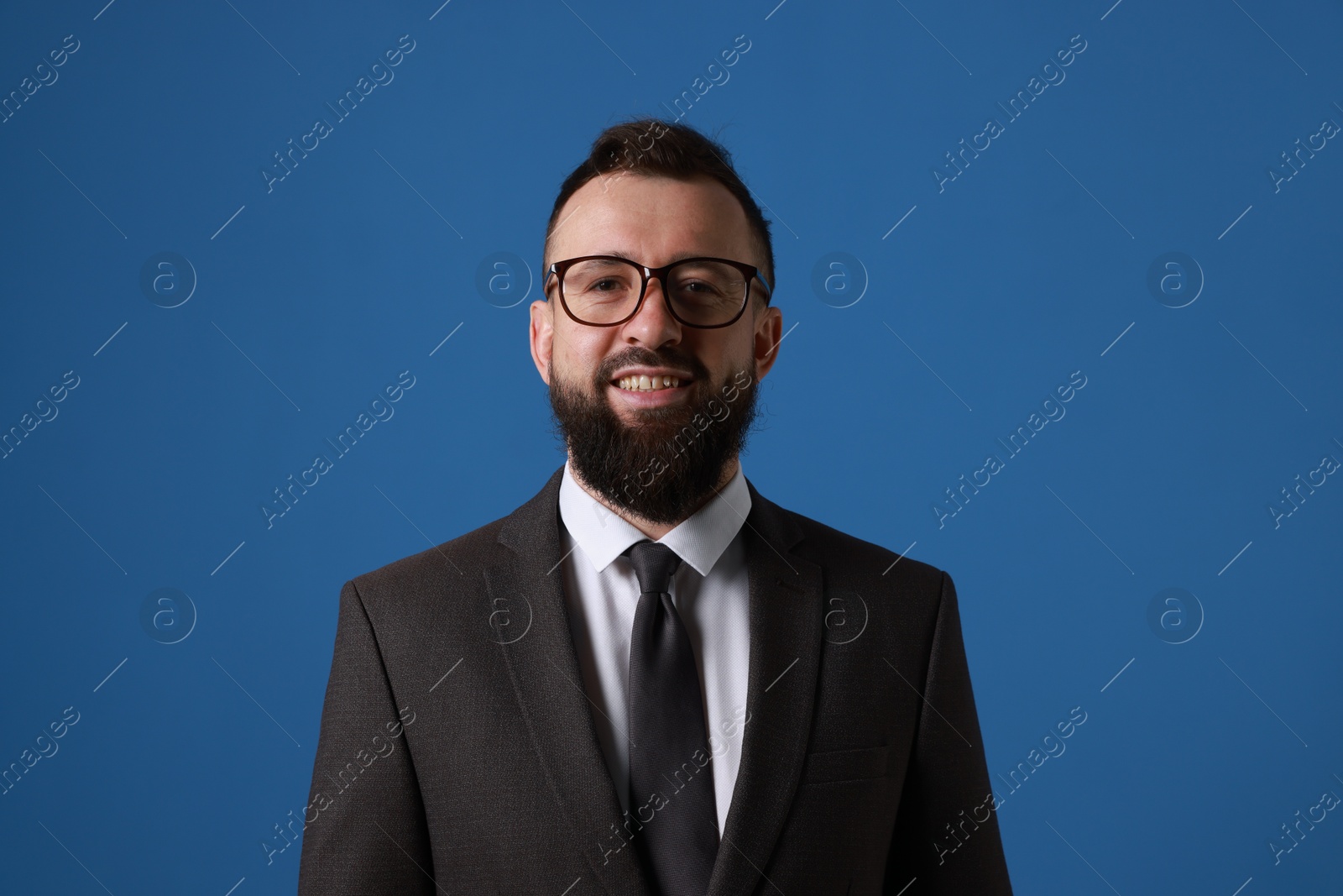 Photo of Handsome bearded man in suit on blue background