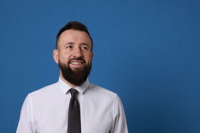 Photo of Handsome bearded man in formal outfit on blue background. Space for text