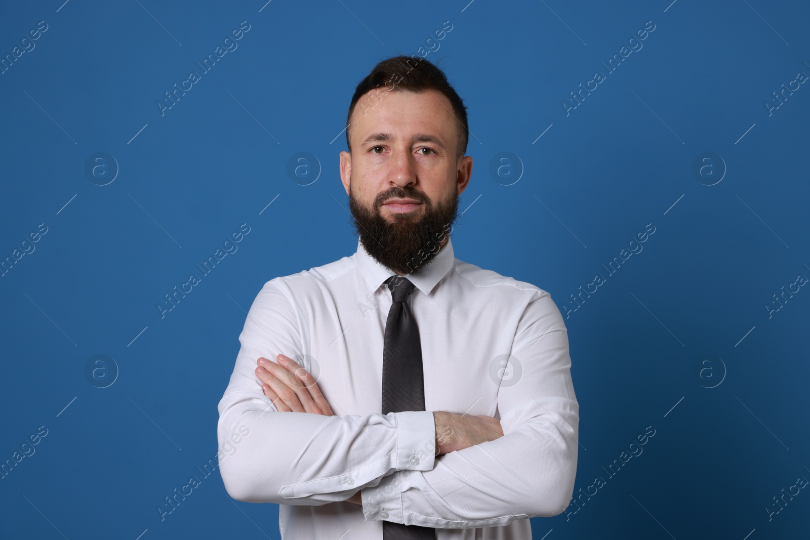 Photo of Handsome bearded man in formal outfit on blue background