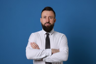 Photo of Handsome bearded man in formal outfit on blue background