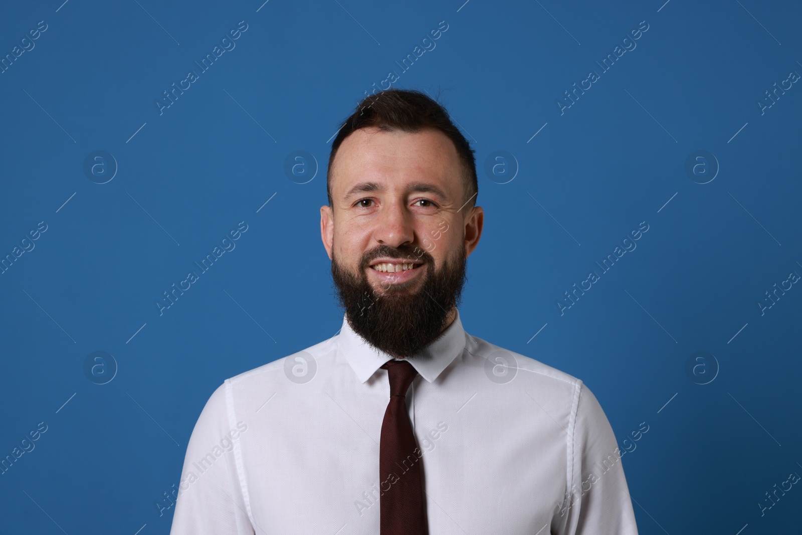 Photo of Handsome bearded man in formal outfit on blue background