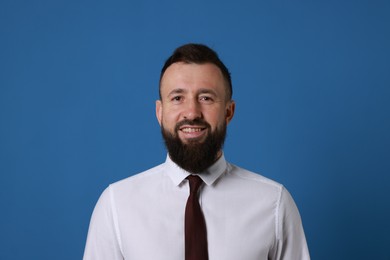 Photo of Handsome bearded man in formal outfit on blue background