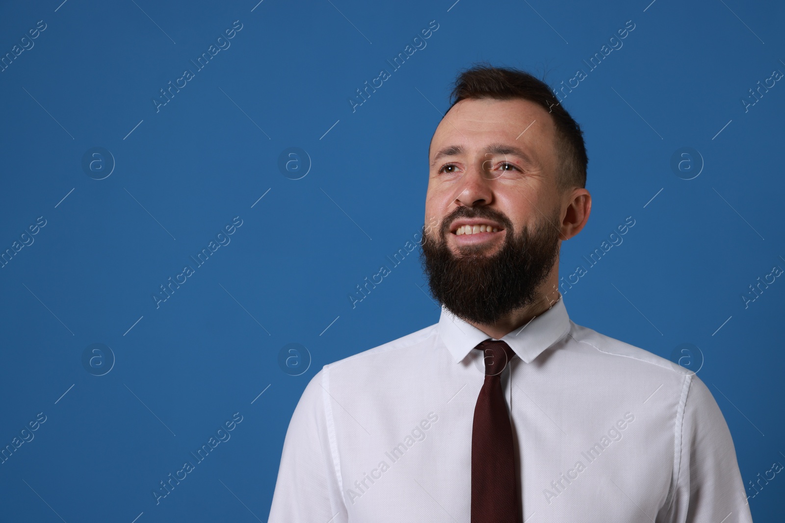 Photo of Handsome bearded man in formal outfit on blue background. Space for text