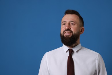 Photo of Handsome bearded man in formal outfit on blue background. Space for text