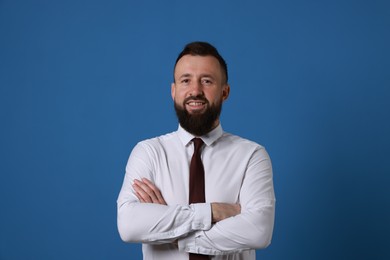 Handsome bearded man in formal outfit on blue background