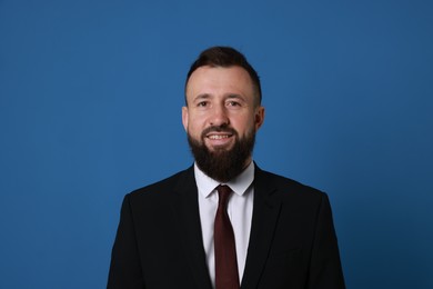 Photo of Handsome bearded man in suit on blue background