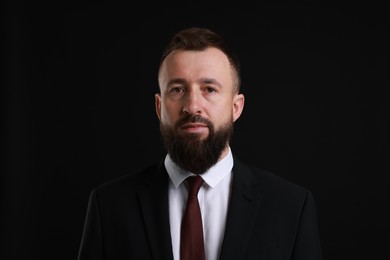 Photo of Handsome bearded man in suit on black background