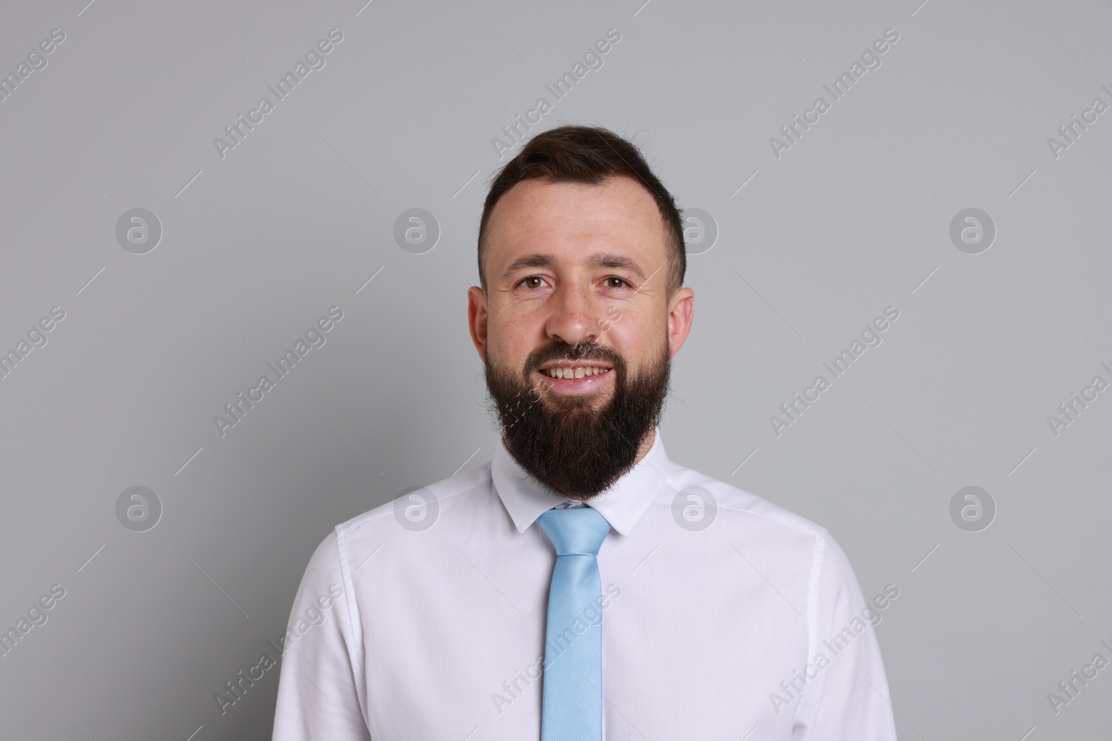 Photo of Handsome bearded man in formal outfit on grey background