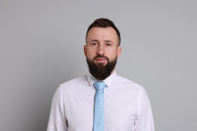 Photo of Handsome bearded man in formal outfit on grey background