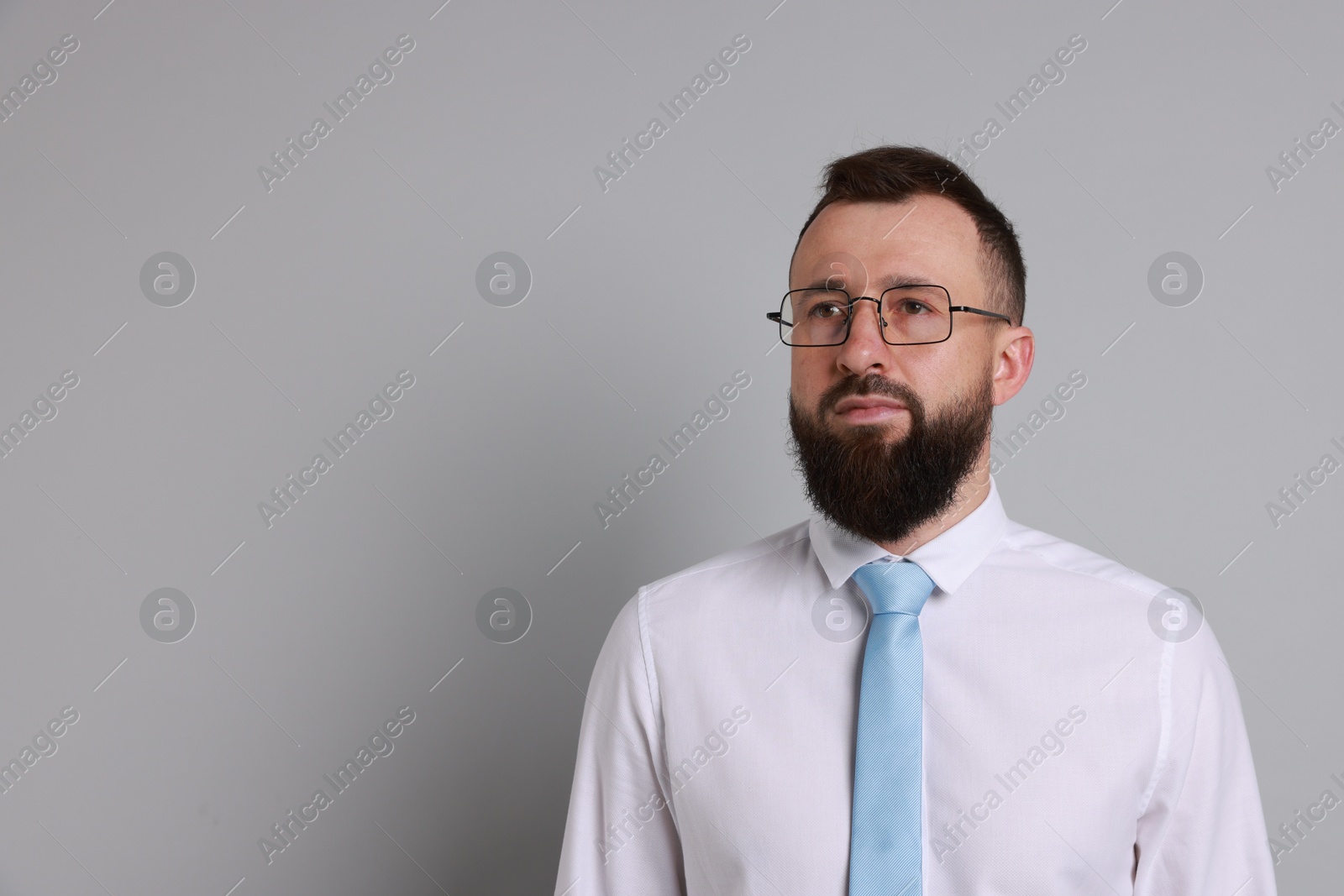 Photo of Handsome bearded man in formal outfit on grey background. Space for text