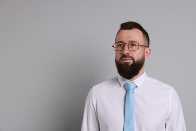 Photo of Handsome bearded man in formal outfit on grey background. Space for text