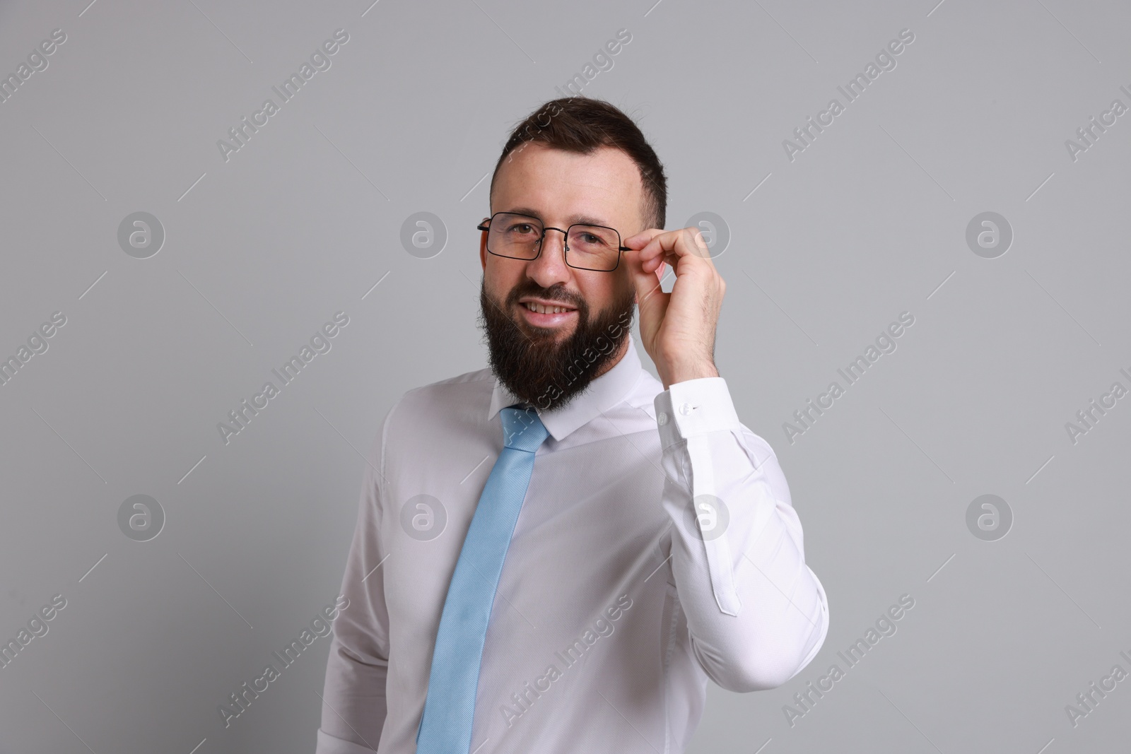 Photo of Handsome bearded man in formal outfit on grey background