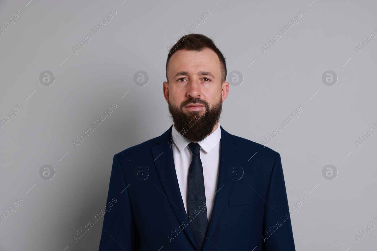 Photo of Handsome bearded man in suit on grey background