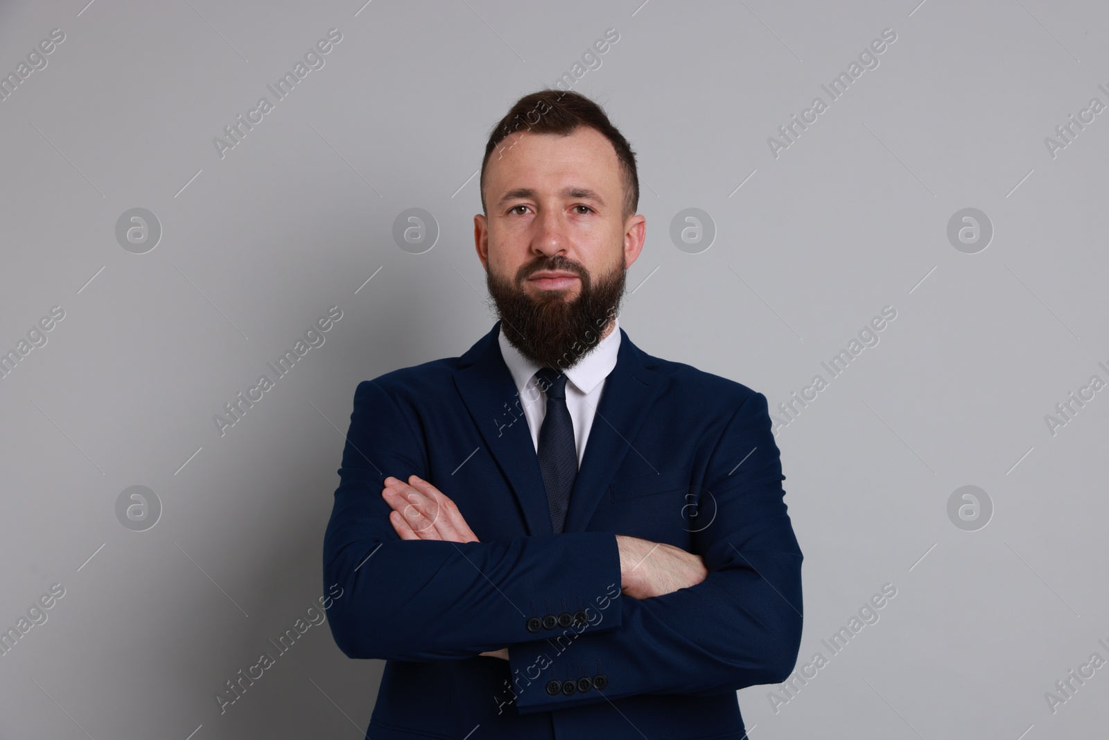 Photo of Handsome bearded man in suit on grey background