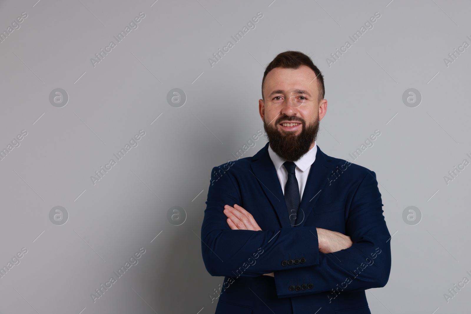 Photo of Handsome bearded man in suit on grey background. Space for text