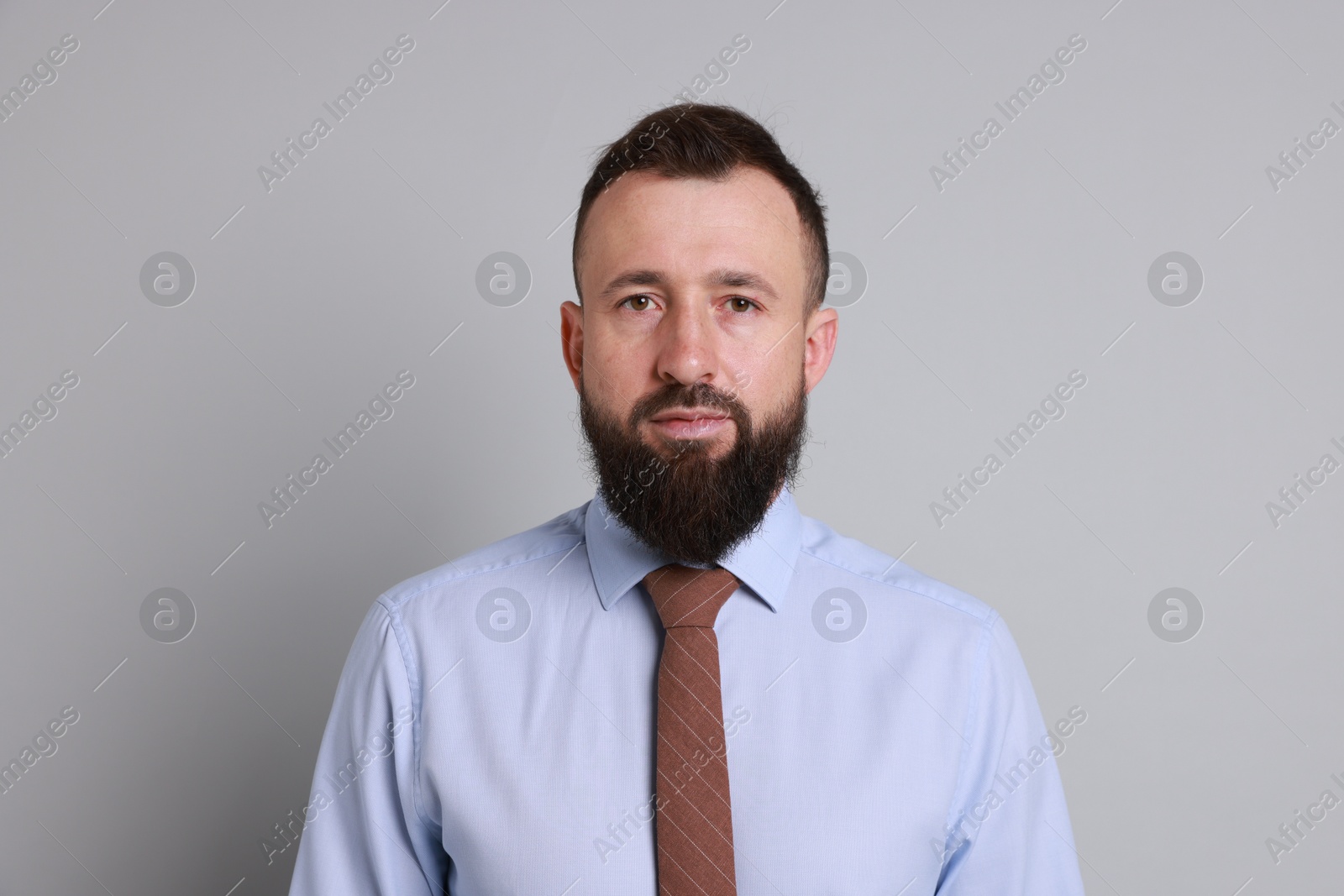 Photo of Handsome bearded man in formal outfit on grey background