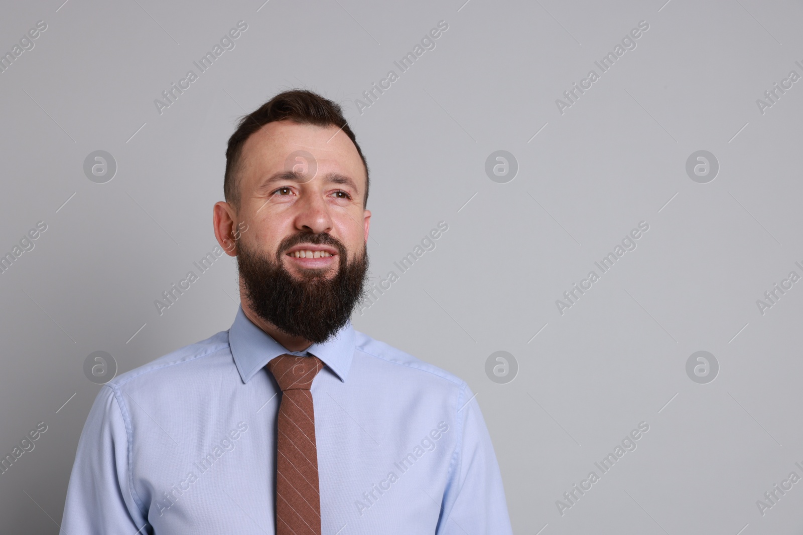 Photo of Handsome bearded man in formal outfit on grey background. Space for text