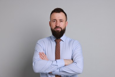 Handsome bearded man in formal outfit on grey background