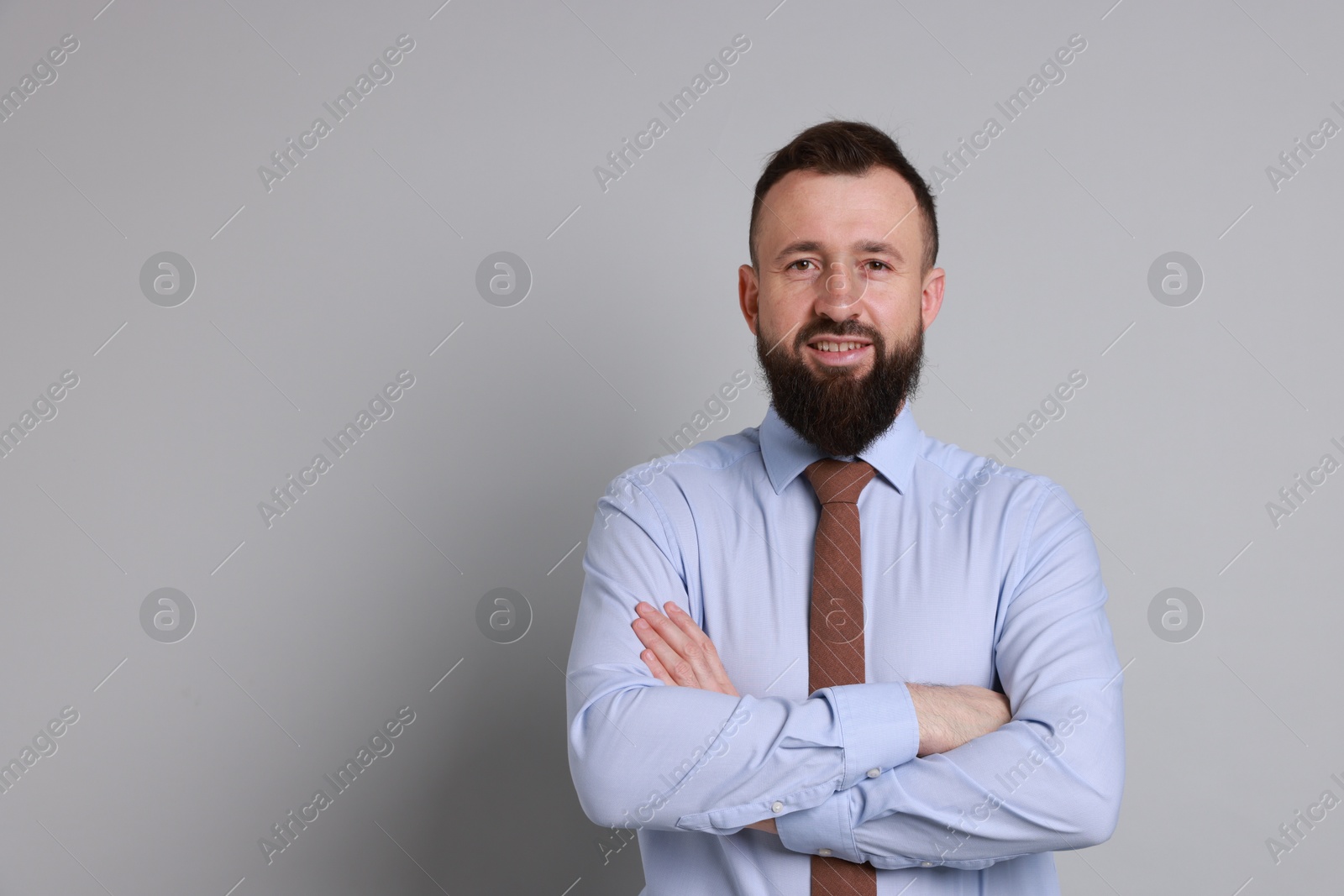 Photo of Handsome bearded man in formal outfit on grey background. Space for text