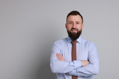 Handsome bearded man in formal outfit on grey background. Space for text