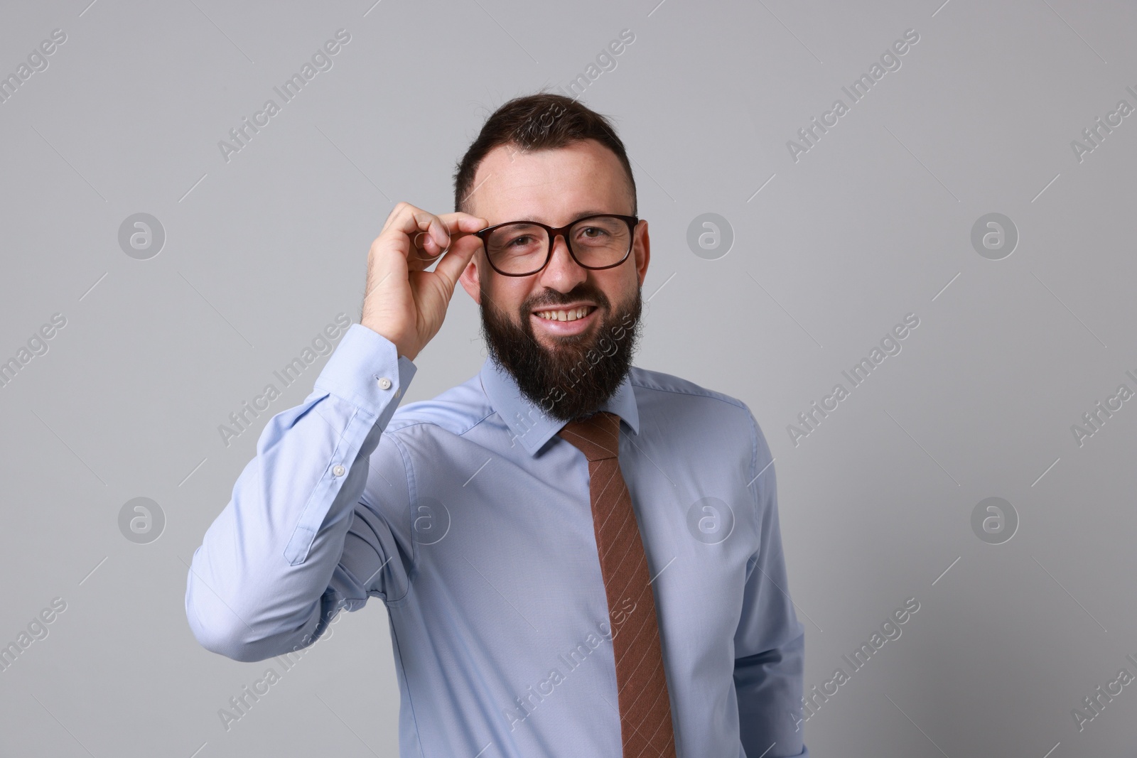 Photo of Handsome bearded man in formal outfit on grey background