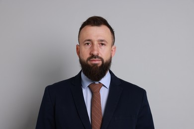 Photo of Handsome bearded man in suit on grey background