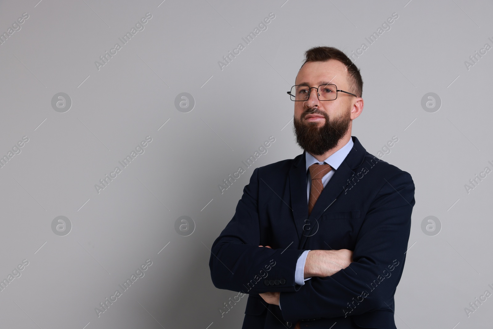 Photo of Handsome bearded man in suit on grey background. Space for text