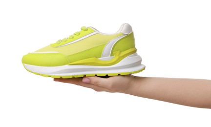 Photo of Woman with neon lime sneaker on white background, closeup