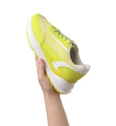 Photo of Woman with neon lime sneaker on white background, closeup