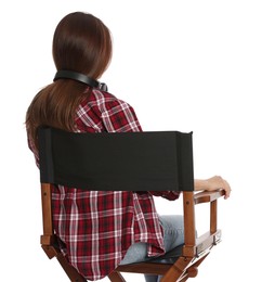 Photo of Woman sitting in director's chair on white background, back view