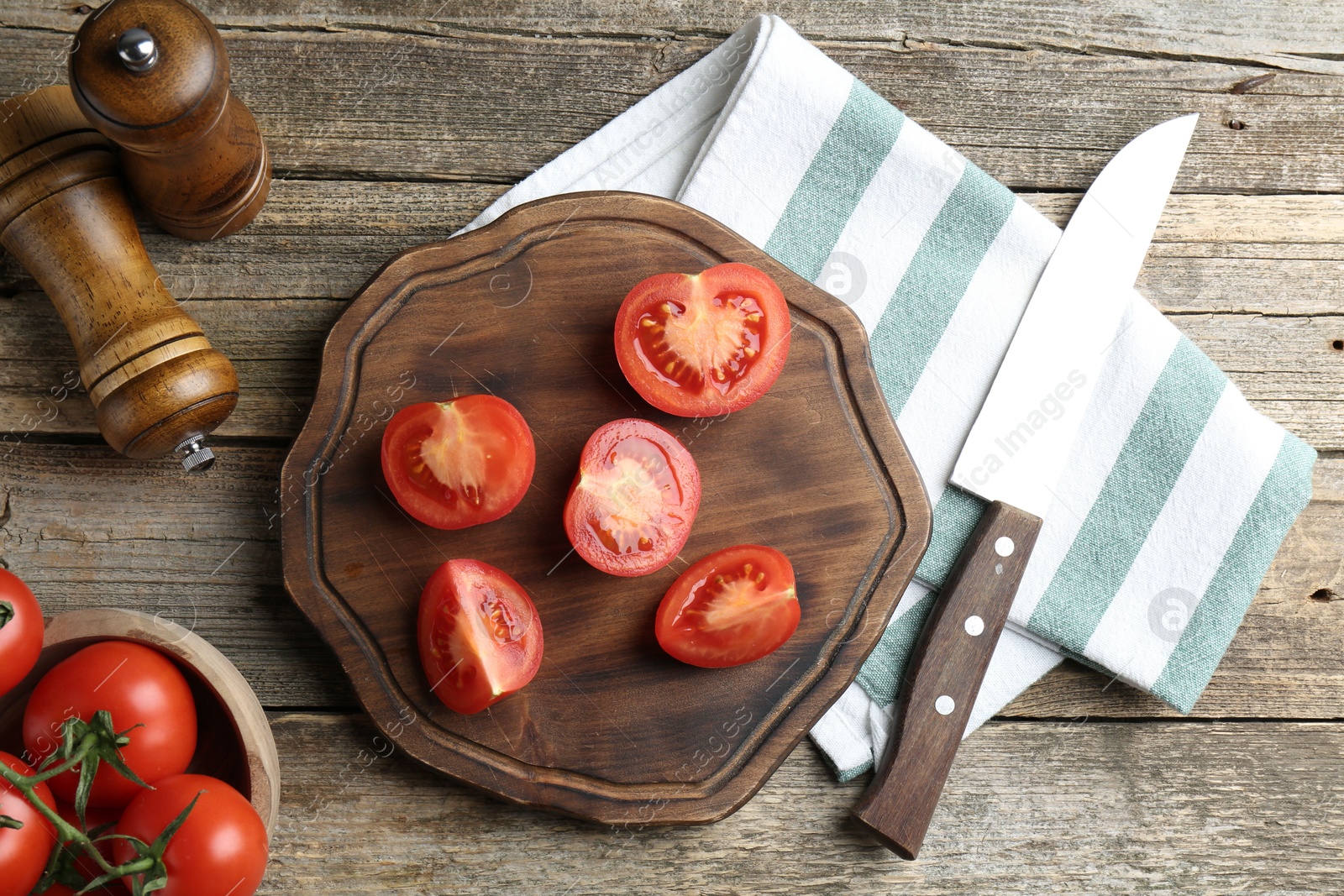 Photo of Cutting board with tomatoes and knife on wooden table, flat lay