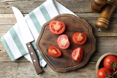 Photo of Cutting board with tomatoes and knife on wooden table, flat lay