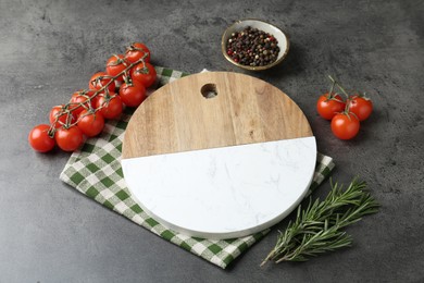 Photo of Cutting board with tomatoes and spices on grey table